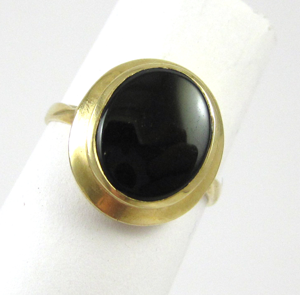 Appraisal: BLACK ONYX AND FOURTEEN KARAT GOLD RING set with an