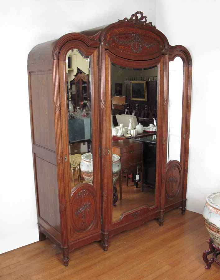 Appraisal: FRENCH VICTORIAN OAK ARMOIRE Triple door with shaped beveled mirrors