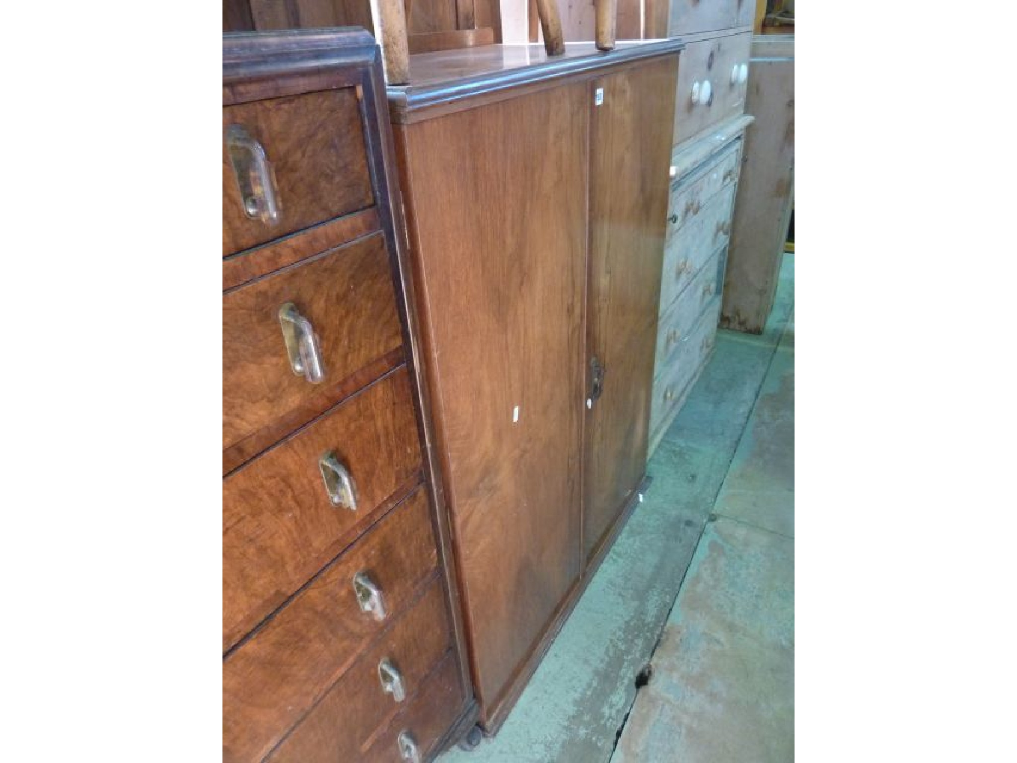 Appraisal: An Art Deco walnut veneered cupboard enclosed by two frieze