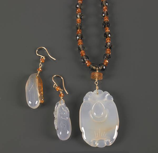 Appraisal: Consisting of a pendant necklace featuring a carved translucent agate