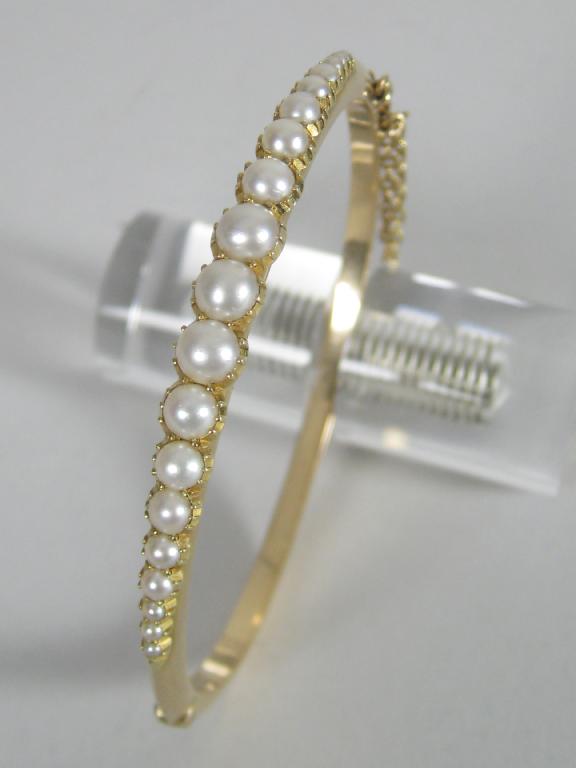 Appraisal: A Victorian hinged Pearl Bangle the front set nineteen graduated