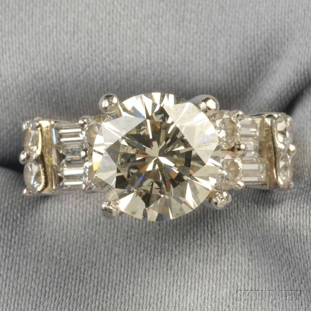 Appraisal: Diamond Solitaire prong-set with a full-cut diamond weighing cts flanked