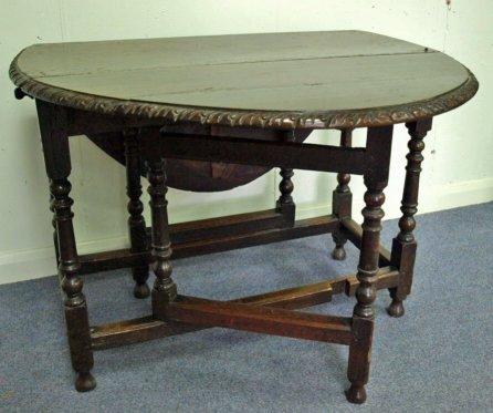 Appraisal: An oak oval two-flap gate-leg table with carved border raised