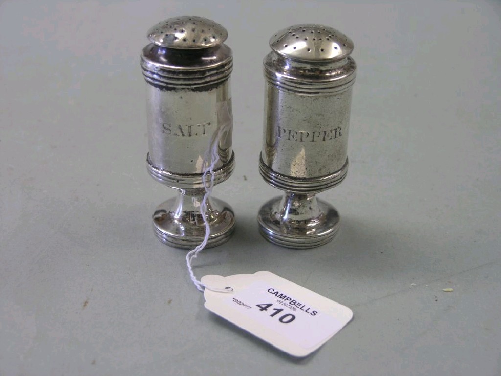 Appraisal: A pair of white metal pepper pots cylindrical form with