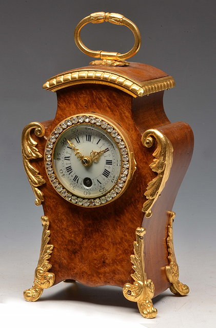 Appraisal: A FRENCH BURR WALNUT BOUDOIR TIMEPIECE the convex white enamel