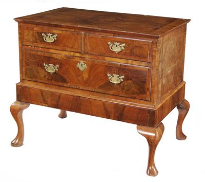 Appraisal: A walnut chest on stand with a quarter veneered top