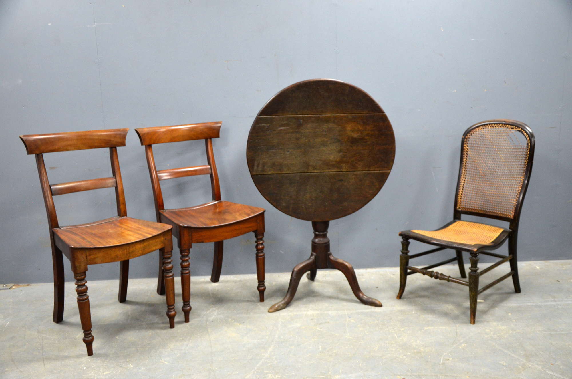 Appraisal: A Georgian oak tripod table with two mahogany chairs and