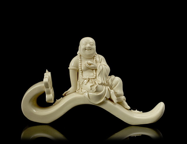 Appraisal: A Chinese Dehua Buddha th Centurythe smiling figure resting on