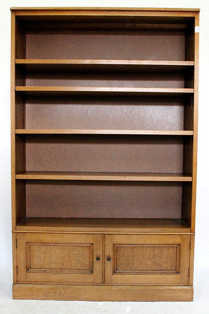 Appraisal: A CONTEMPORARY LIGHT OAK OPEN BOOKCASE with fielded panel cupboard