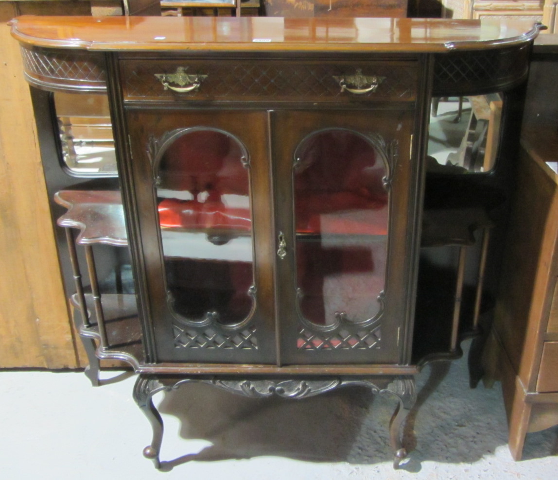 Appraisal: A mahogany display cabinet flanked with mirrored back shelves together