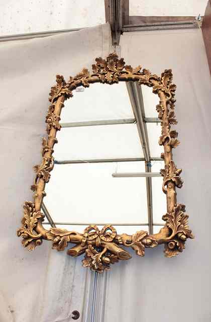 Appraisal: A GILT FRAMED HANGING WALL MIRROR with naturalistically moulded frame