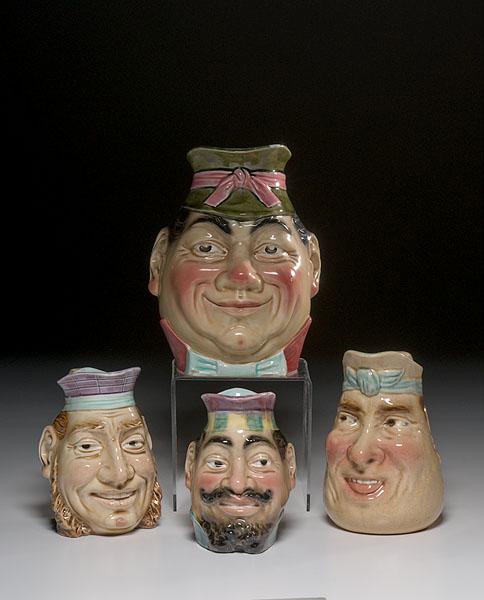 Appraisal: FOUR SARREGUEMINES MAJOLICA FACE PITCHERS Continental late th century Includes