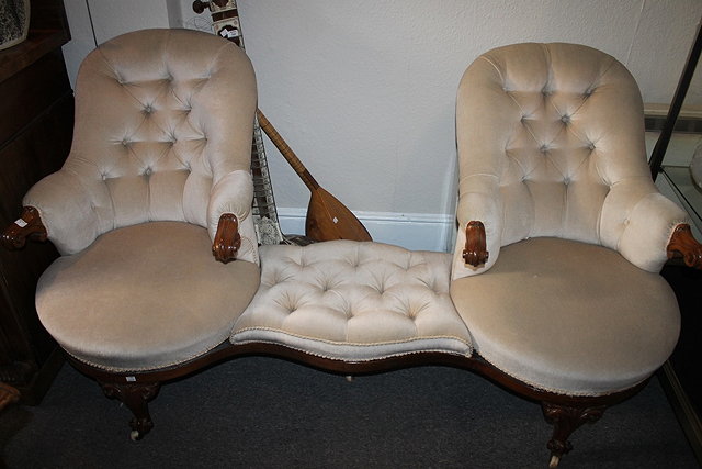 Appraisal: A VICTORIAN WALNUT FRAMED CONVERSATION SOFA with buttoned dralon upholstery