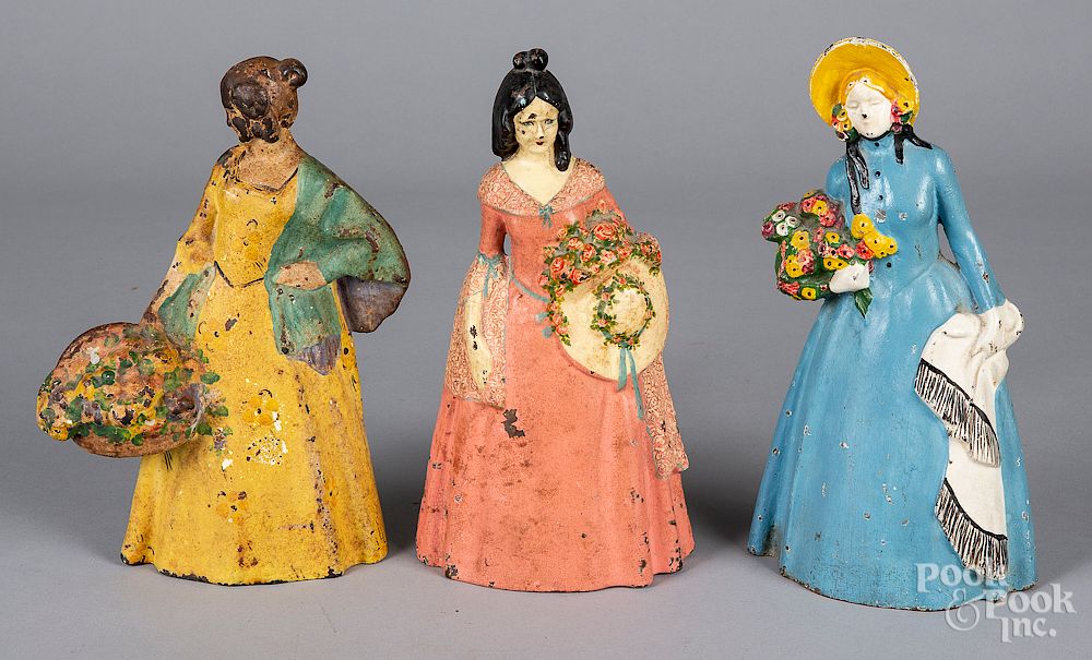 Appraisal: Three cast iron women with flowers doorstops Three cast iron