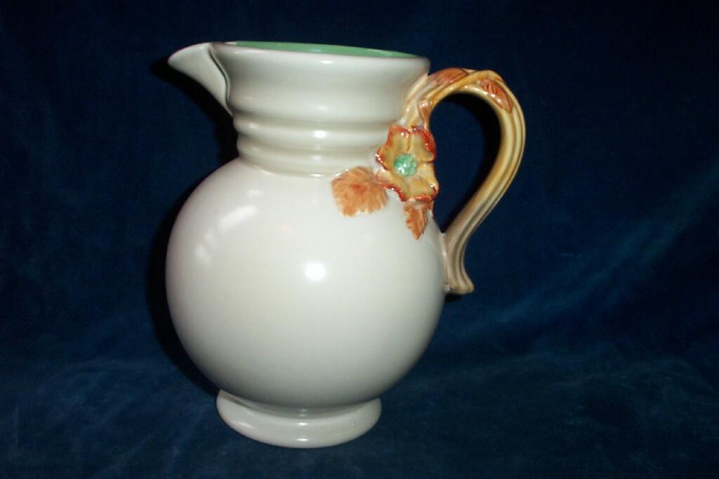 Appraisal: A Clarice Cliff cream glazed jug with moulded handle in