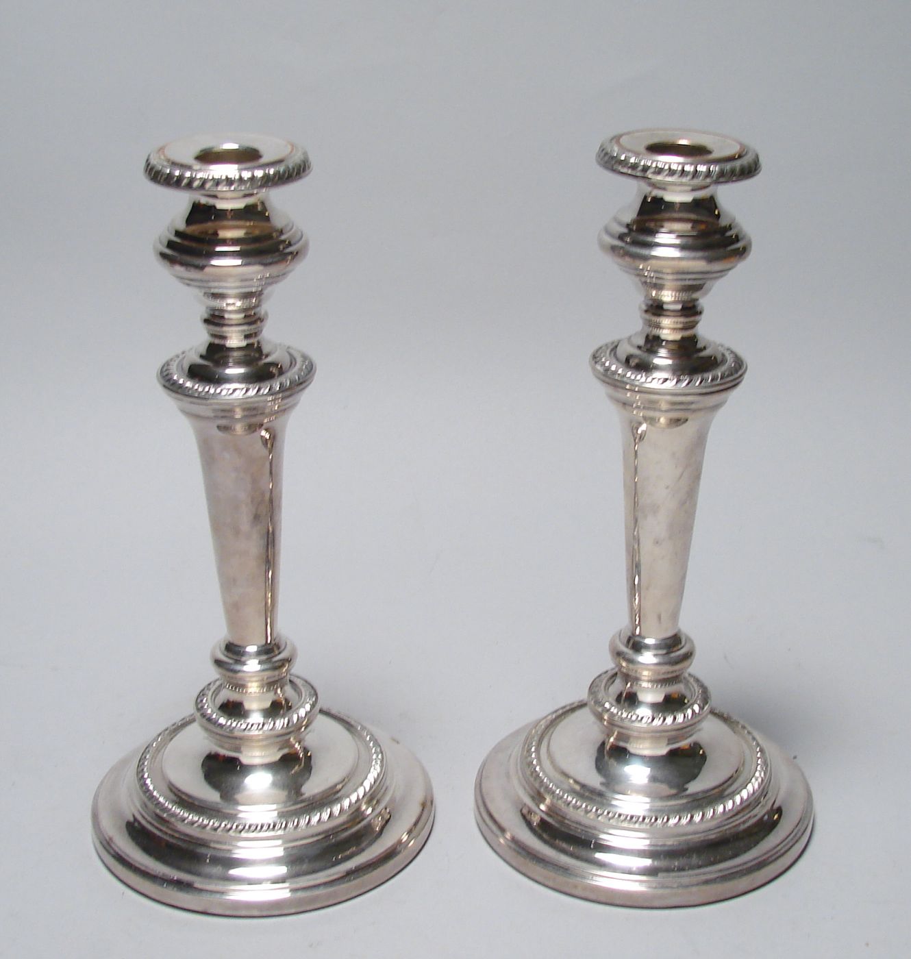 Appraisal: PAIR OF ENGLISH SILVER PLATED CANDLESTICKS In tapering circular column