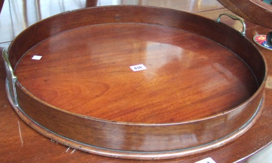 Appraisal: An early th century mahogany circular serving tray with brass