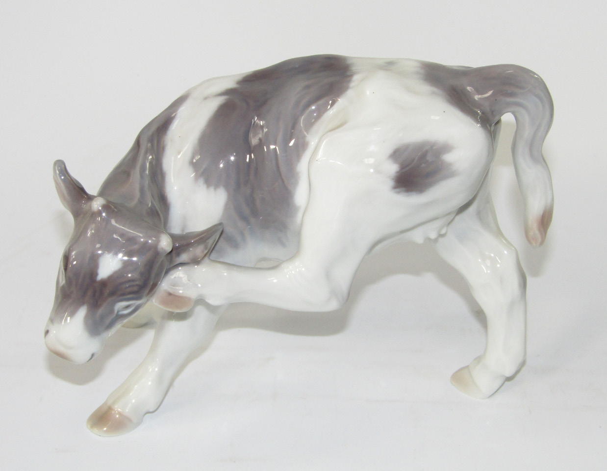 Appraisal: A Royal Copenhagen model of a Friesian heifer scratching its