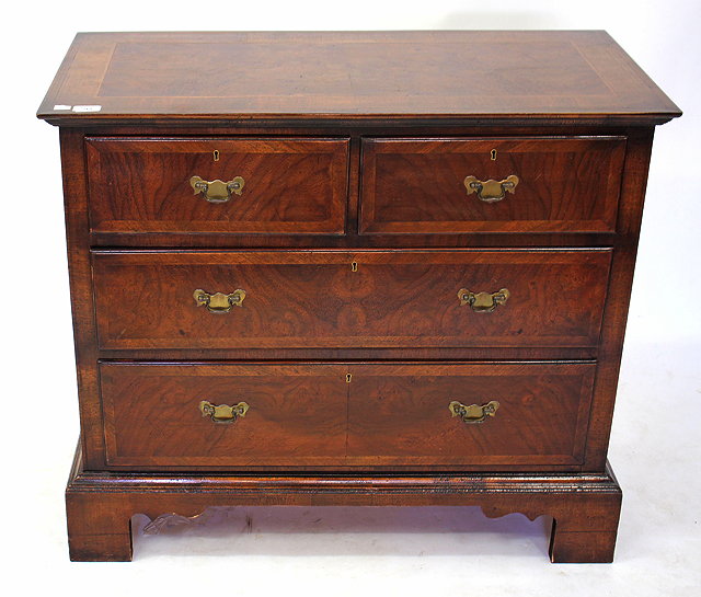 Appraisal: A REPRODUCTION WALNUT CHEST of two short and two long