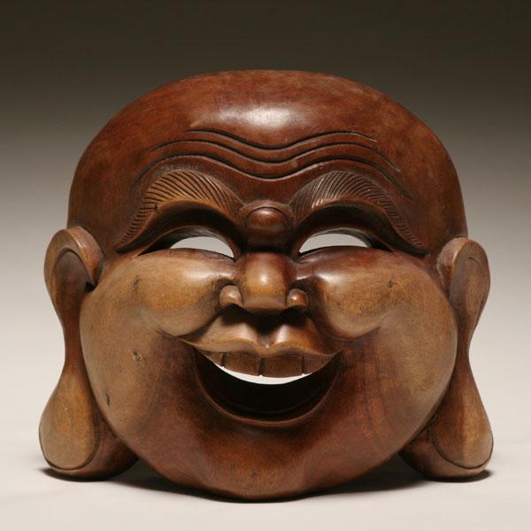 Appraisal: Carved wooden mask of a laughing Buddha H x W