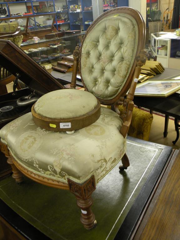 Appraisal: A Victorian carved walnut nursing chair with a button back