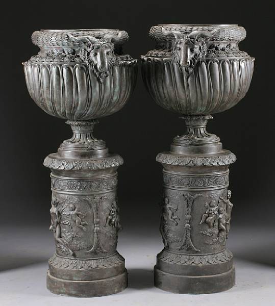 Appraisal: A pair of Neoclassical style patinated bronze urns on integral