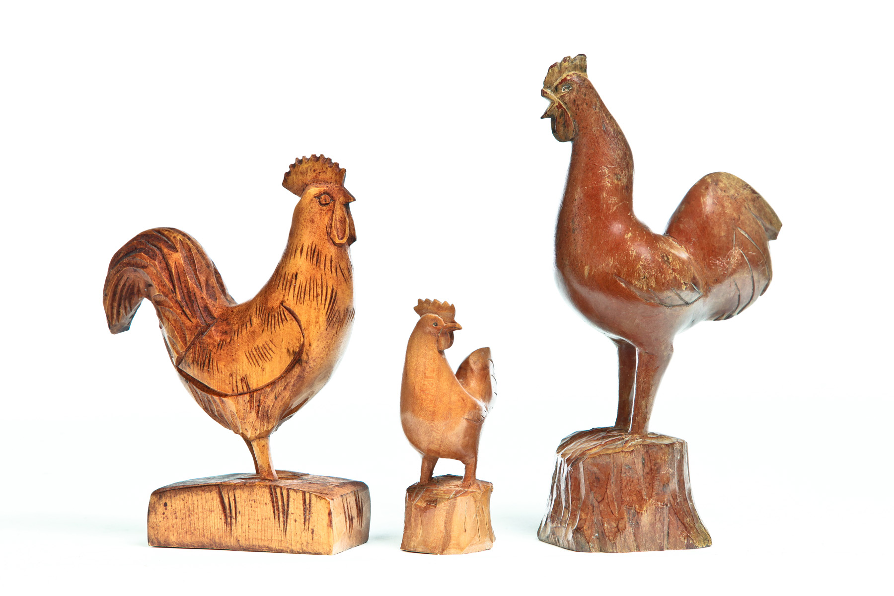 Appraisal: THREE AMERICAN FOLK ART CARVED ROOSTERS Mid th century Two