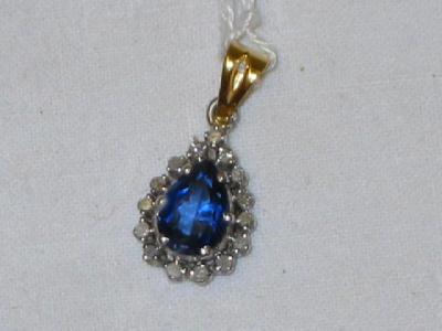 Appraisal: A PALE SAPPHIRE PENDANT of drop form surrounded by fifteen