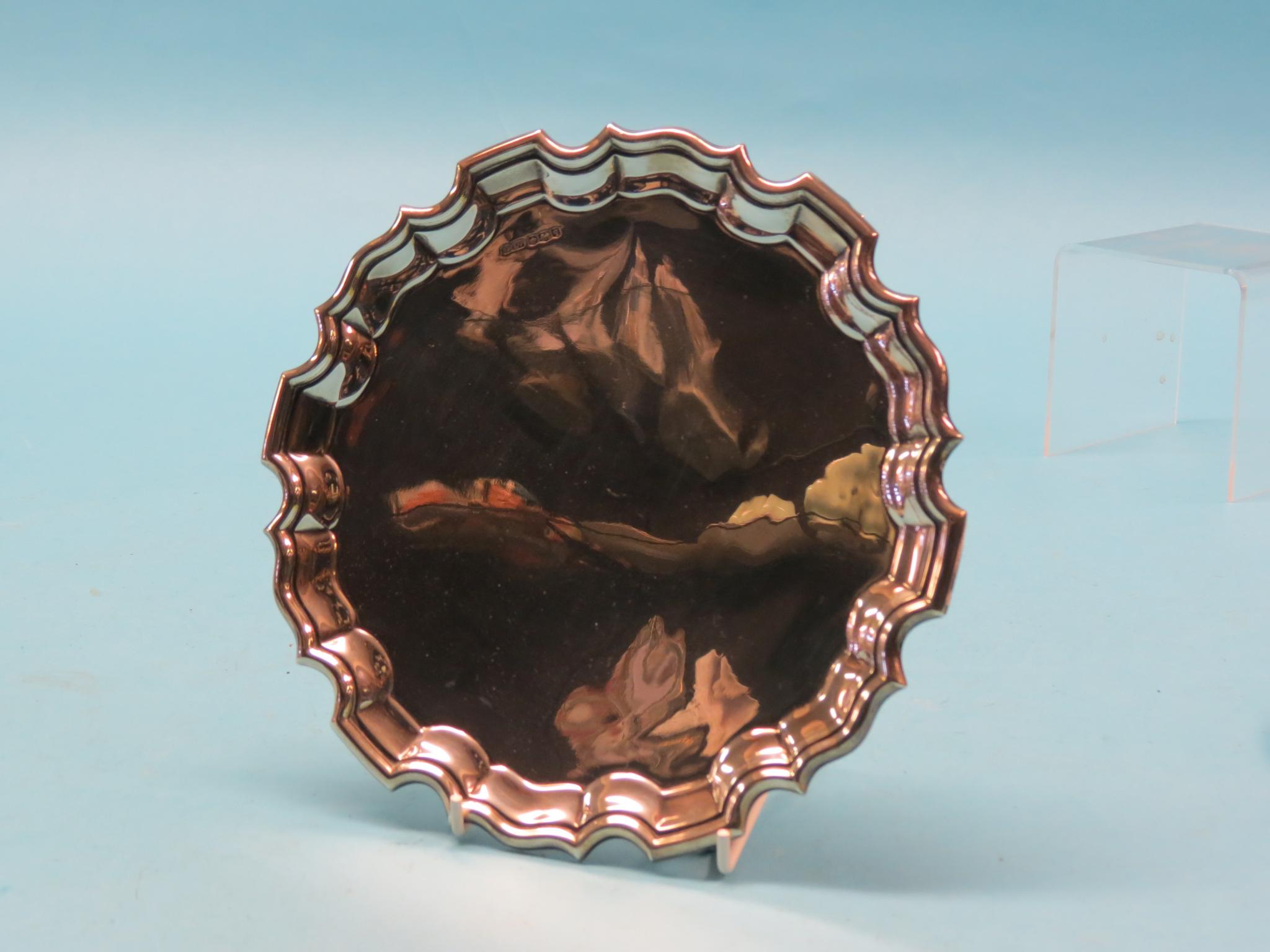 Appraisal: A silver card tray circular with scalloped border on three