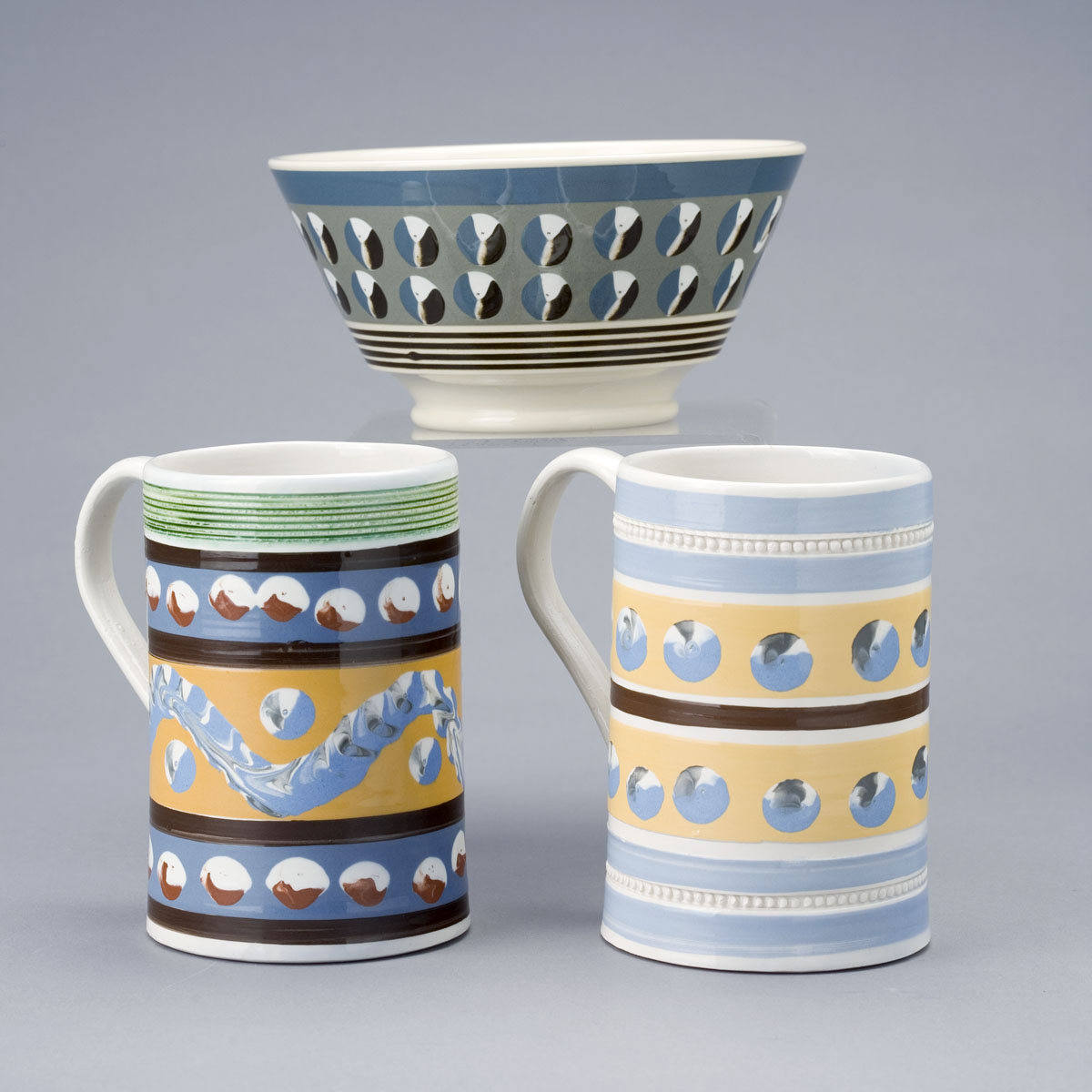 Appraisal: TWO REPRODUCTION MOCHAWARE MUGS AND A LONDON-SHAPE BOWL BY DONALD