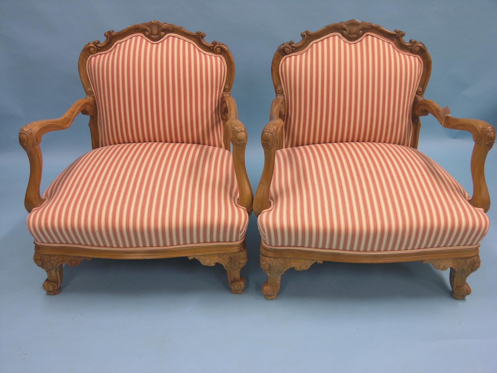 Appraisal: A pair of walnut-framed low armchairs carved scroll top rails