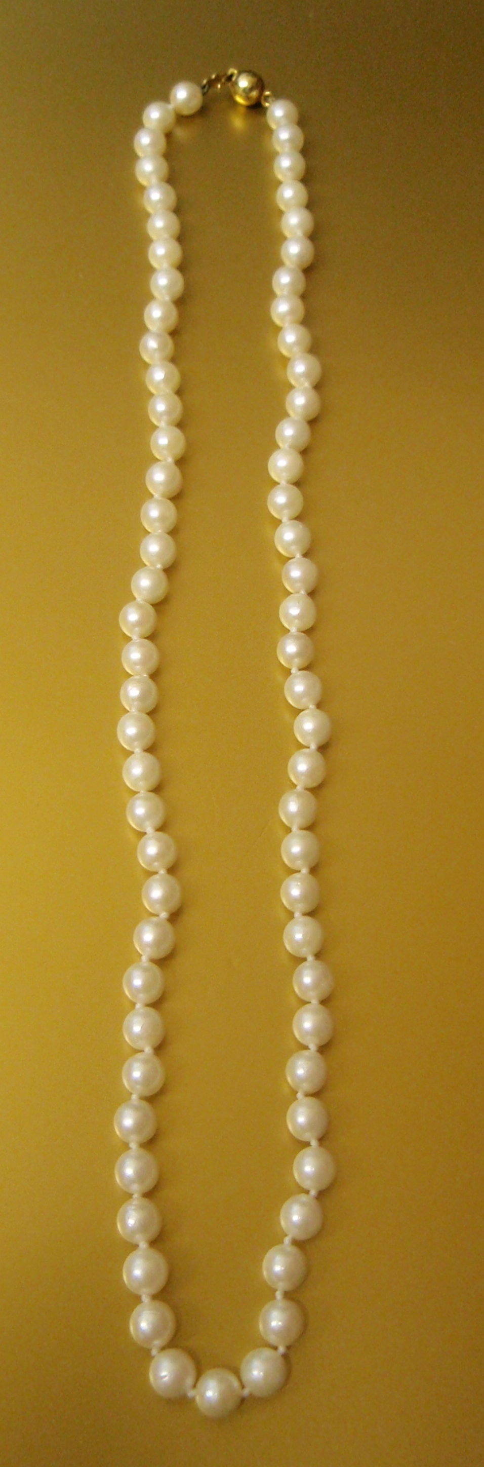 Appraisal: A single row of cultured pearls with a yellow metal