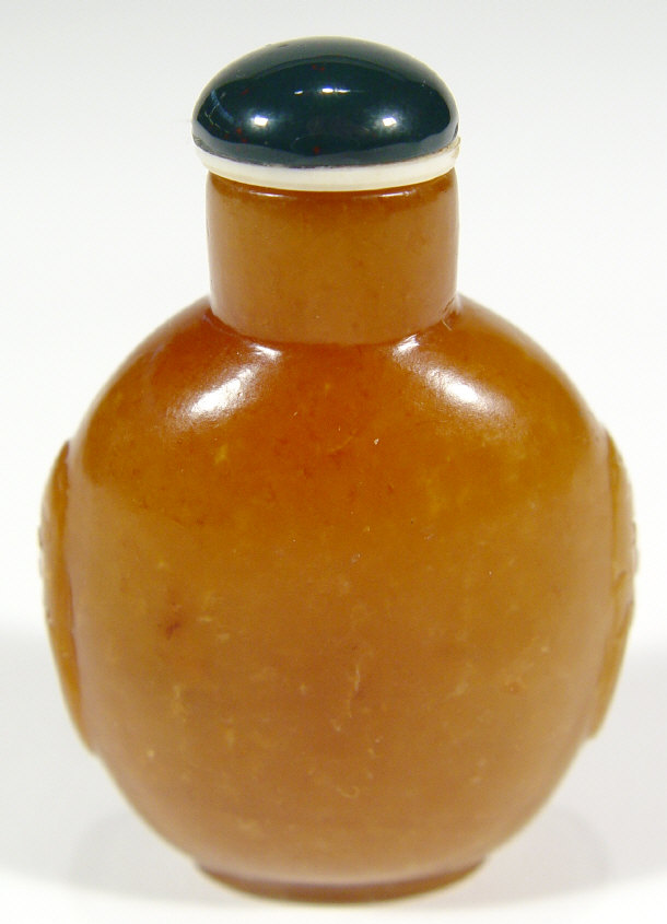 Appraisal: Chinese orange coloured stone snuff bottle with mask handles cm