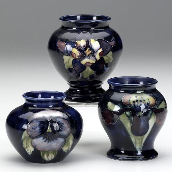 Appraisal: MOORCROFT Three cabinet vases one in the Pansy pattern one