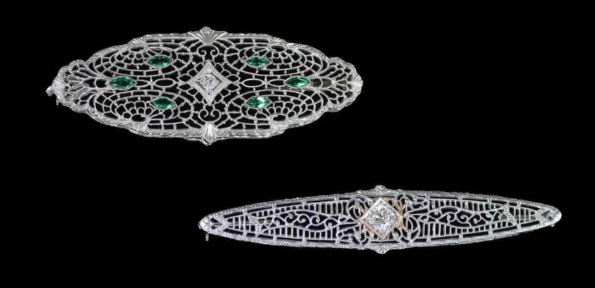 Appraisal: FILIGREE DIAMOND PINS Two K filigree pins contain round full