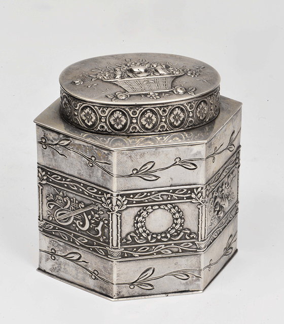 Appraisal: A CONTINENTAL HEXAGONAL WHITE METAL TEA CANISTER decorated with laurel