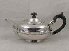 Appraisal: A silver teapot of flattened globe form with central band