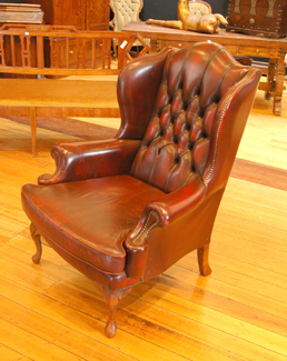 Appraisal: A QUEEN ANNE STYLE ARMCHAIR The arched buttoned leather upholstered