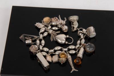 Appraisal: A white metal charm bracelet hung with a variety of