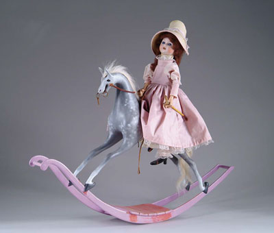 Appraisal: CLOCKWORK ROCKING HORSE WITH DOLL ASTRIDE Of more recent vintage