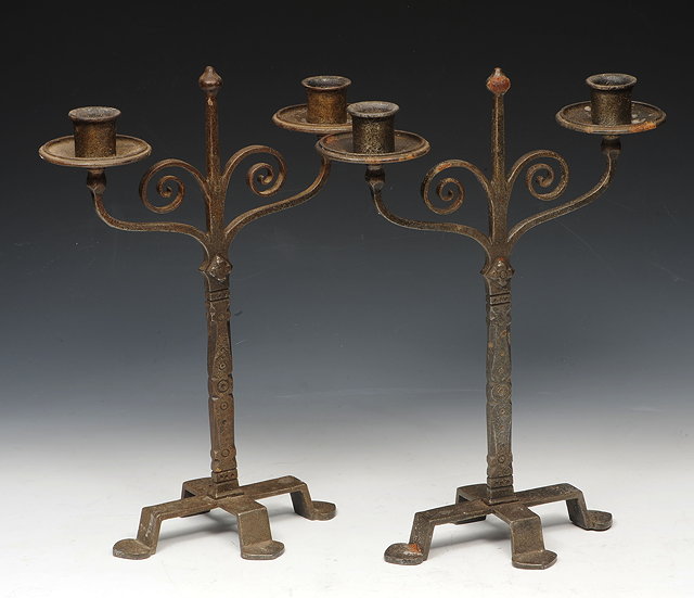 Appraisal: A PAIR OF COTSWOLD STYLE IRON TWO BRANCH CANDELABRA cm