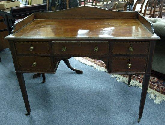 Appraisal: An Edwardian mahogany kneehole dressing table with three-quarter gallery back