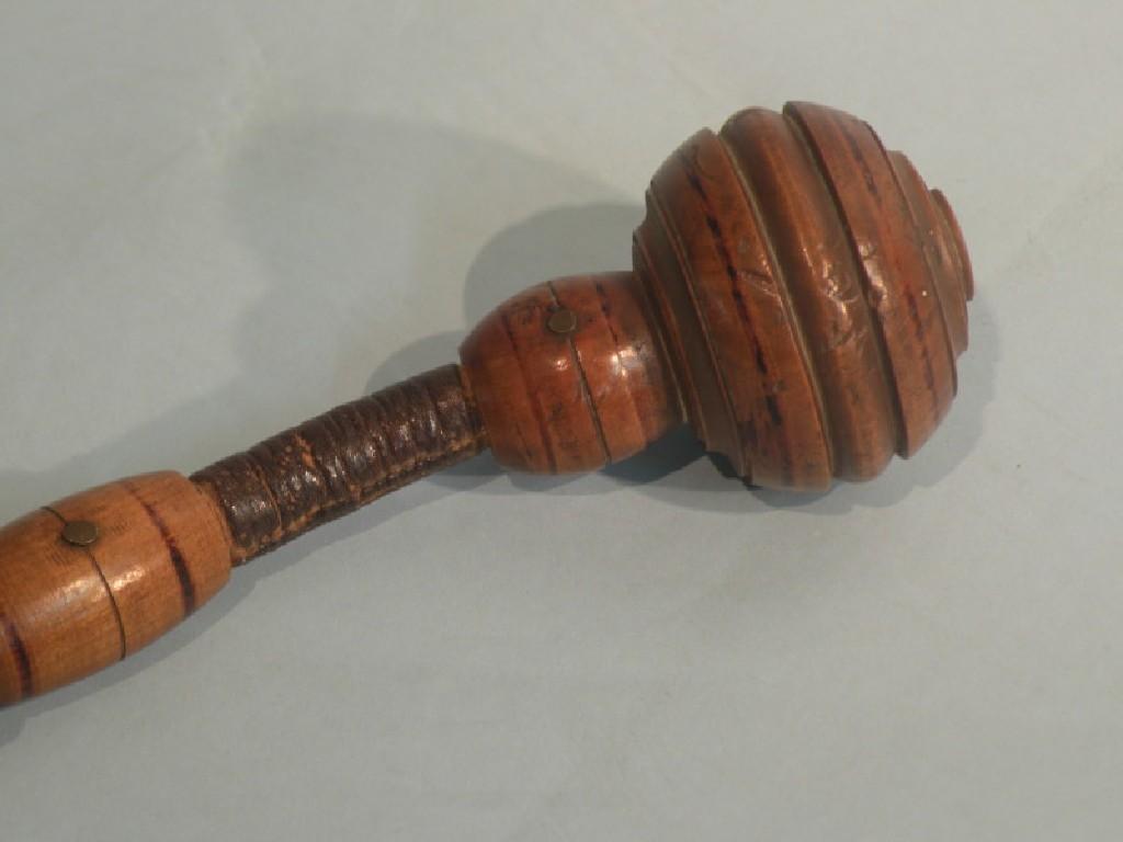 Appraisal: A Continental turned fruitwood and leather articulated truncheon or cosh