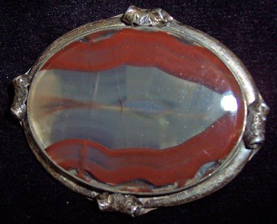 Appraisal: An oval brown agate brooch silver mounted the flat collar