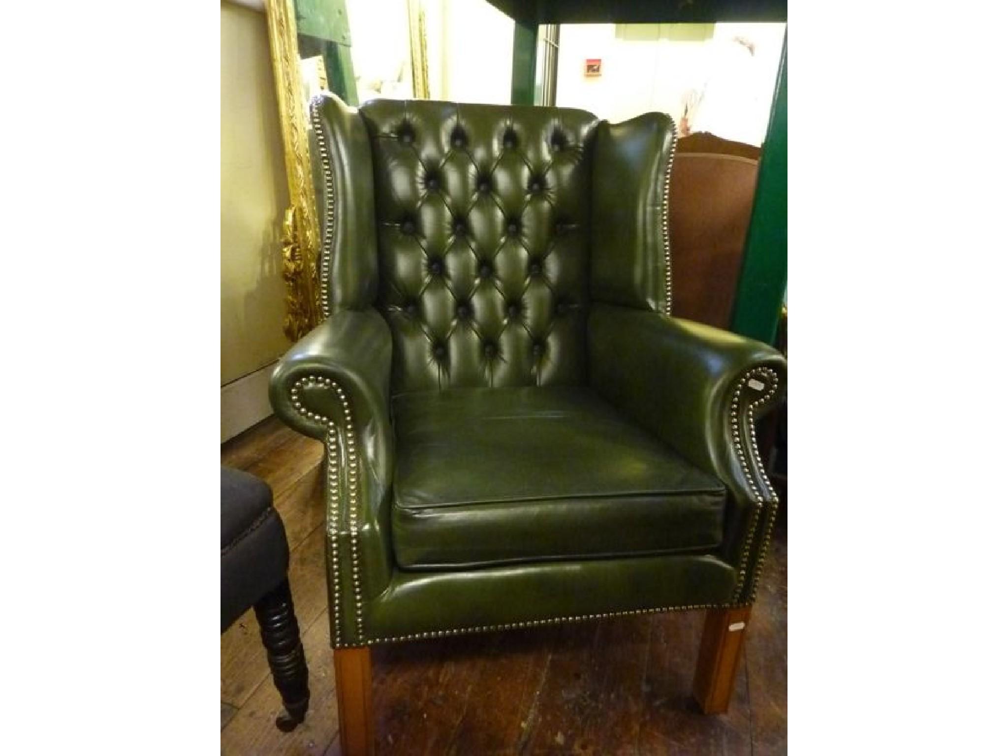 Appraisal: A pair of Georgian style green leather upholstered wing armchairs