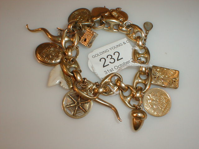 Appraisal: A hollow link charm bracelet with fifteen charms including two