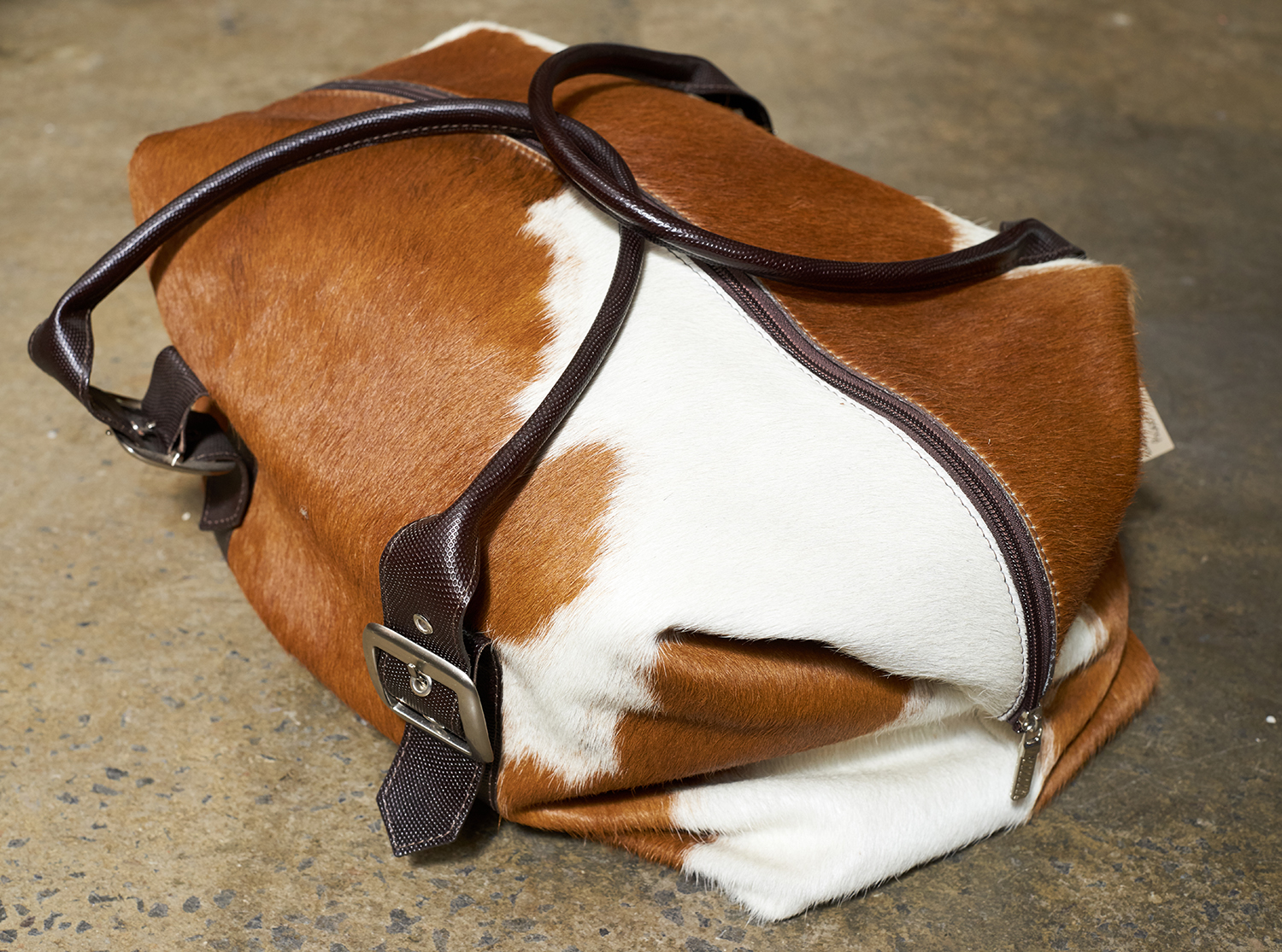 Appraisal: AN AUSTRALIAN MADE COW HIDE BAG Suede lining with pockets