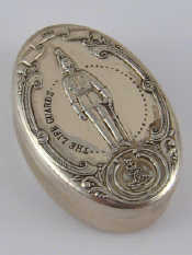 Appraisal: A silver oval pill box the lid embossed with a