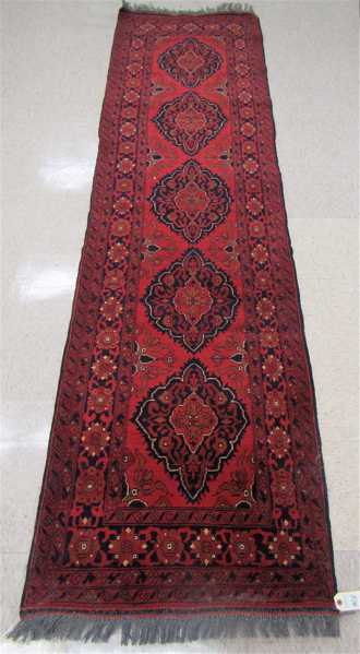 Appraisal: HAND KNOTTED AFGHAN RUNNER five medallion design on red wine