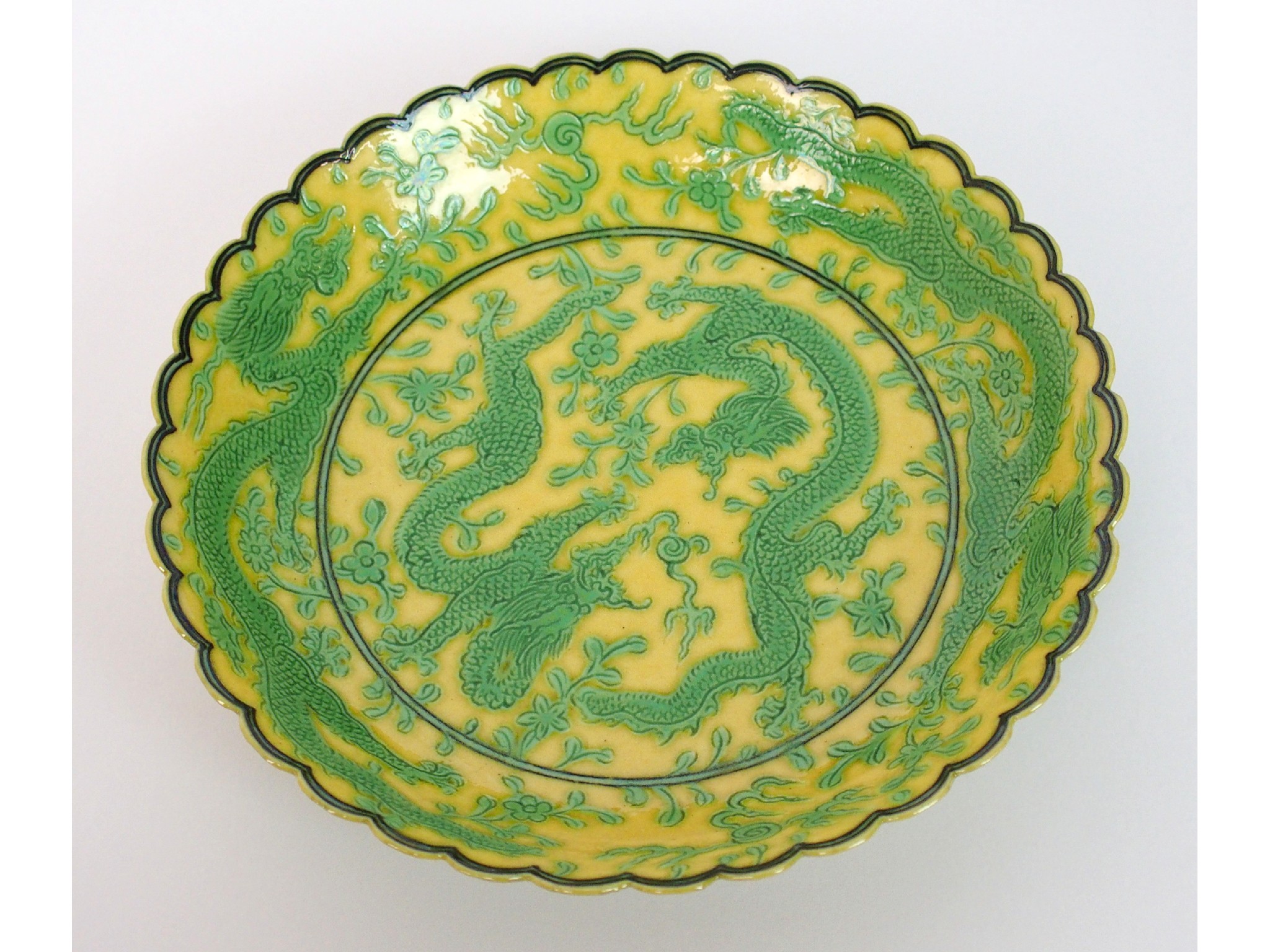 Appraisal: A Chinese saucerincised with dragons chasing flaming pearls on a